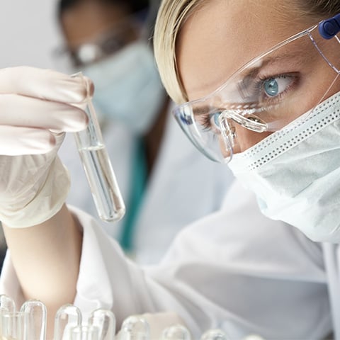 Wissenschaftler im Labor untersucht Flüssigkeit in einem Reagenzglas.