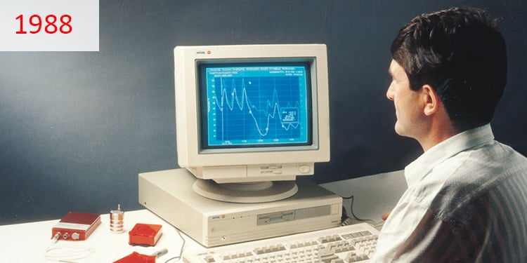 1988 Ein Mann sitzt an seinem Arbeitsplatz und bedient einen Computer aus den 1980er Jahren.
