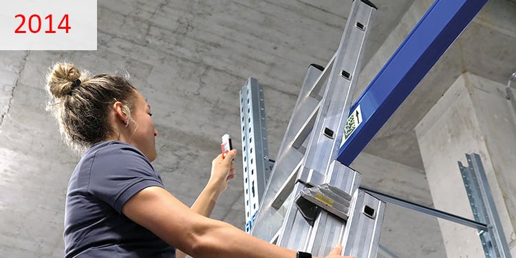 2014 Eine Frau auf einer Leiter in einem Kühlhaus demontiert einen Temperaturlogger.