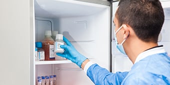 Pharmacist takes vaccine out of fridge.
