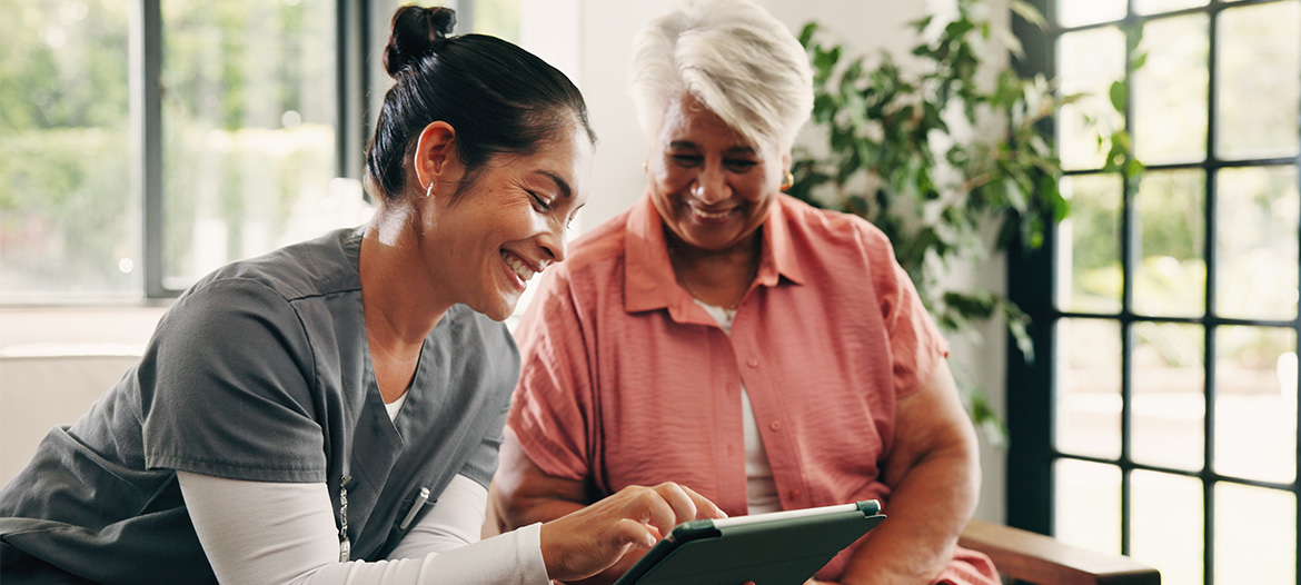 Mitarbeitende im Gesundheitswesen und Patientin betrachten gemeinsam Informationen auf einem Tablet und stehen für digitale Innovation, datenbasierte Entscheidungen und moderne Prozesse im Gesundheitswesen.