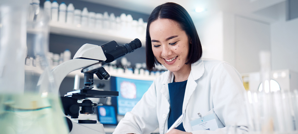 Laboratory professional analyzing samples with a microscope in a modern research laboratory environment.