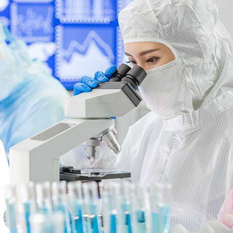 Wissenschaftler im Labor, die durch Mikroskope schauen.