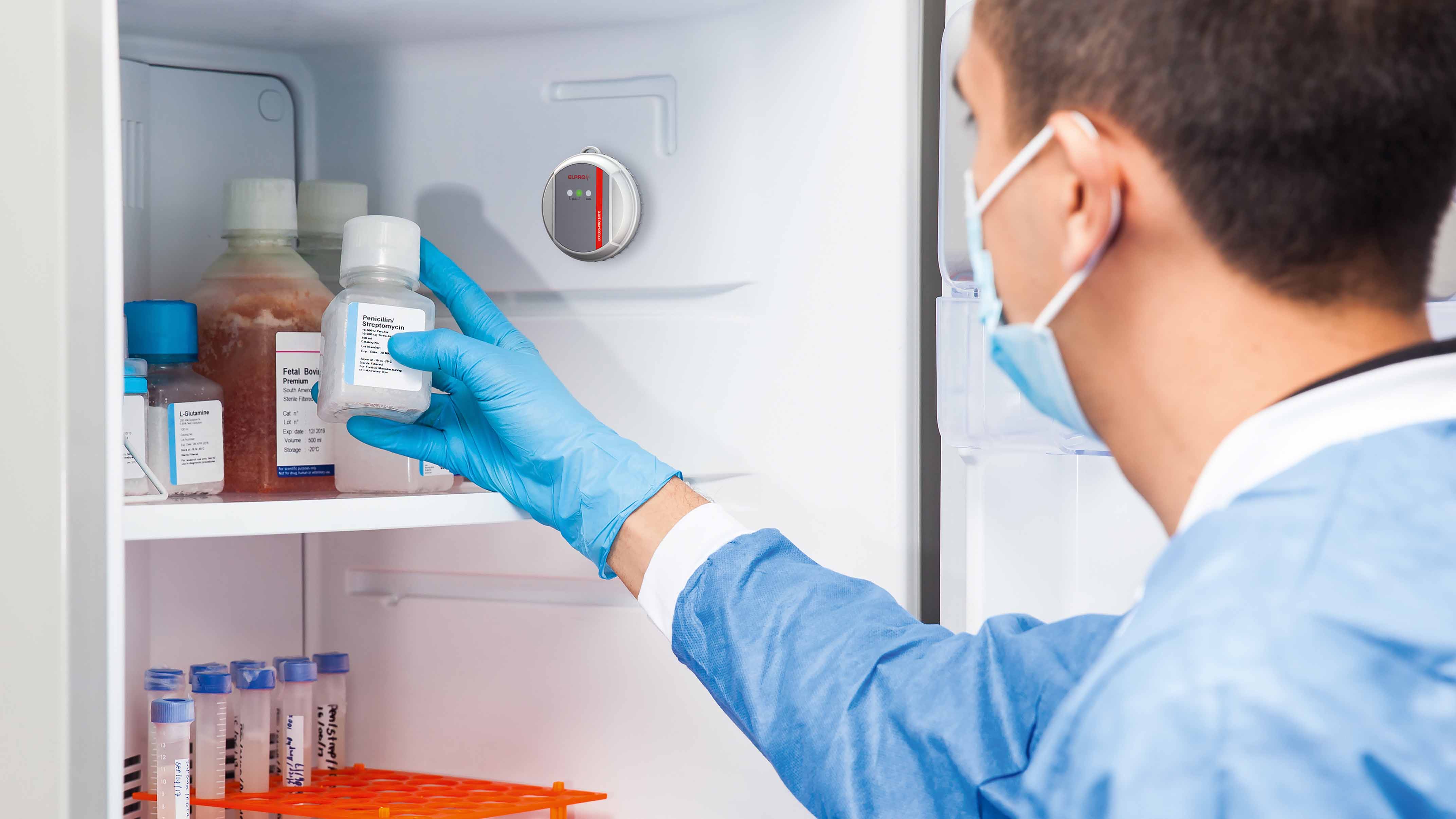 Laboratory technician takes a vaccine bottle out of the refrigerator.