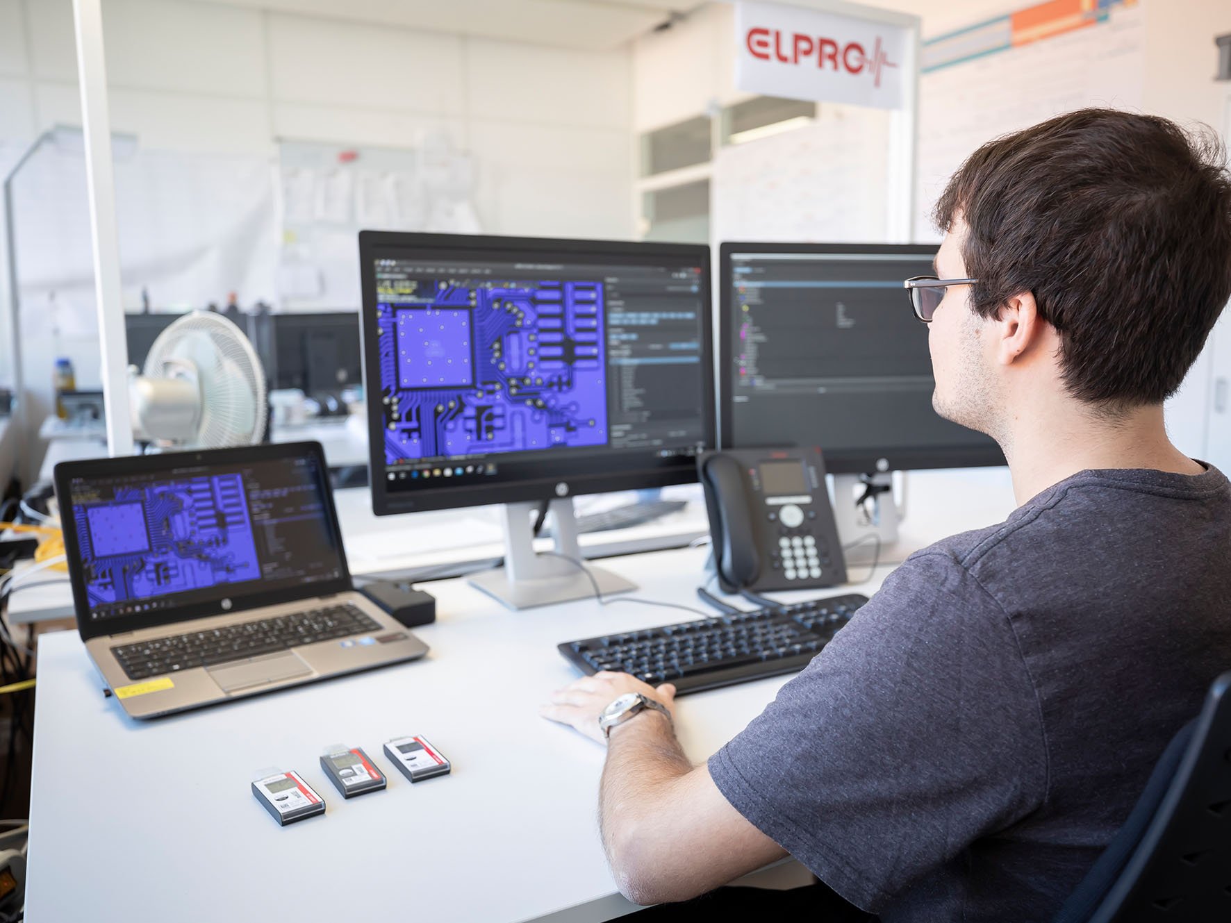 Ein Mann sitzt vor einem Computer und analysiert Daten.