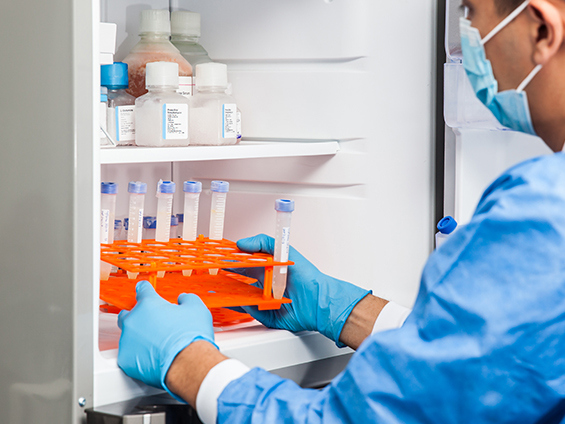 Laboratory technician takes vaccine vials out of the freezer.