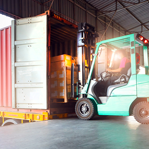 Forklift on loading ramp unloading pallet from truck.